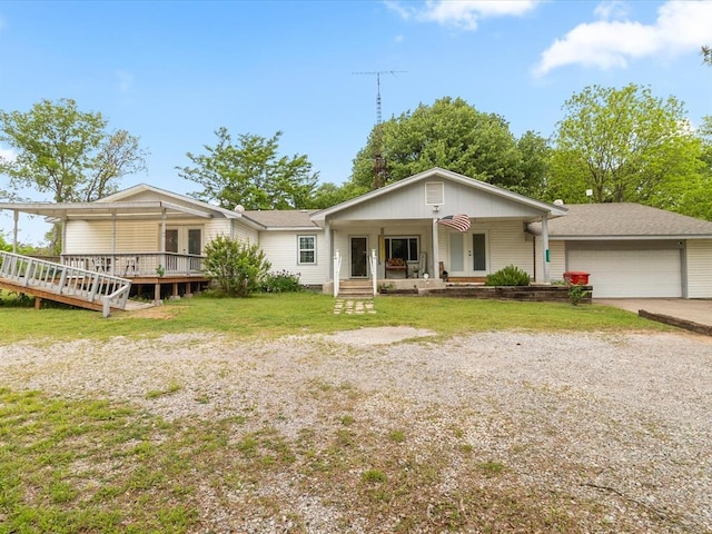 view of front of house with covered porch, a garage, and a front yard