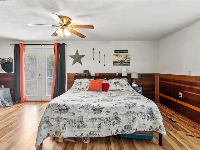 bedroom featuring access to exterior, french doors, a textured ceiling, ceiling fan, and hardwood / wood-style flooring