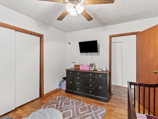 bedroom featuring ceiling fan, light wood-type flooring, and a textured ceiling