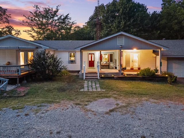 view of front of property featuring a yard, a porch, and a garage