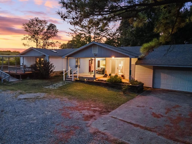 single story home featuring a yard, a porch, and a garage