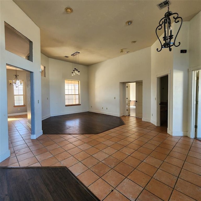 spare room featuring tile patterned flooring and a high ceiling