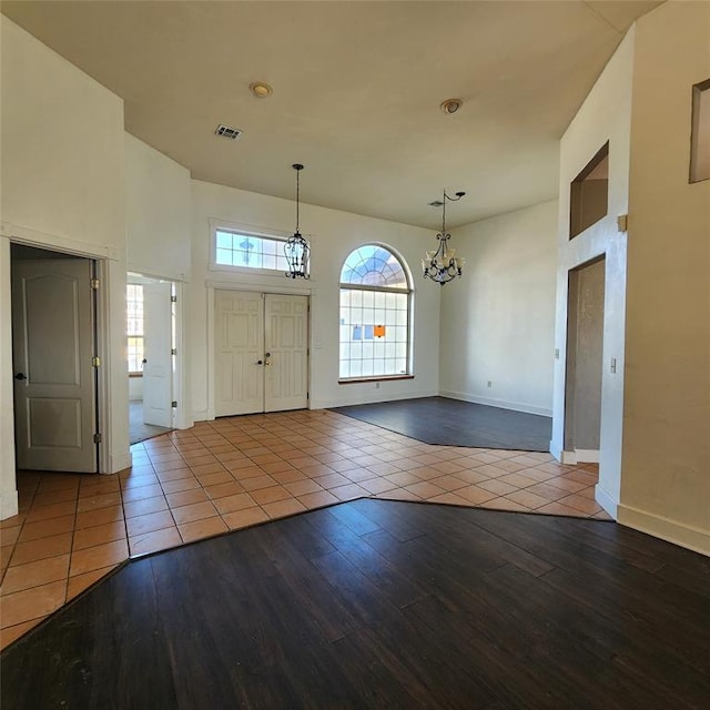 tiled entryway with a notable chandelier