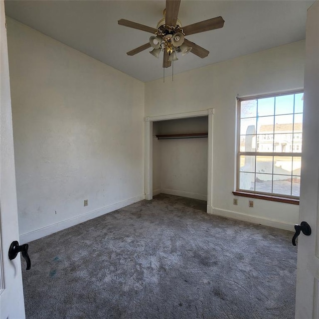 unfurnished bedroom featuring ceiling fan, dark carpet, and a closet