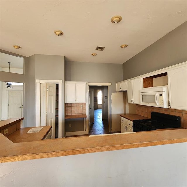 kitchen with pendant lighting, black range with gas stovetop, white cabinetry, and tasteful backsplash