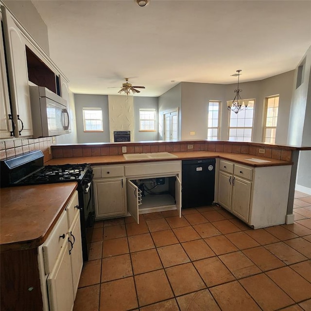 kitchen featuring black appliances, ceiling fan with notable chandelier, light tile patterned floors, decorative light fixtures, and kitchen peninsula