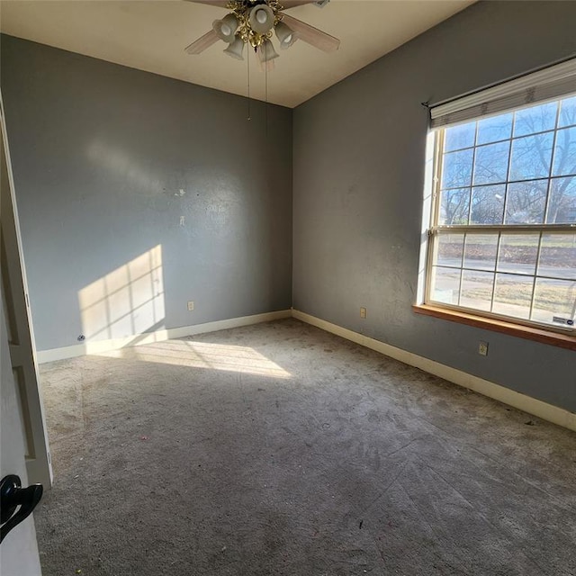 carpeted spare room featuring ceiling fan