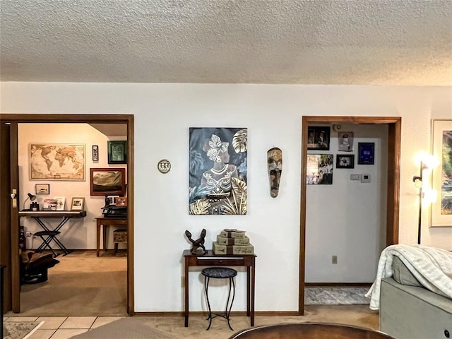 hall with light carpet and a textured ceiling