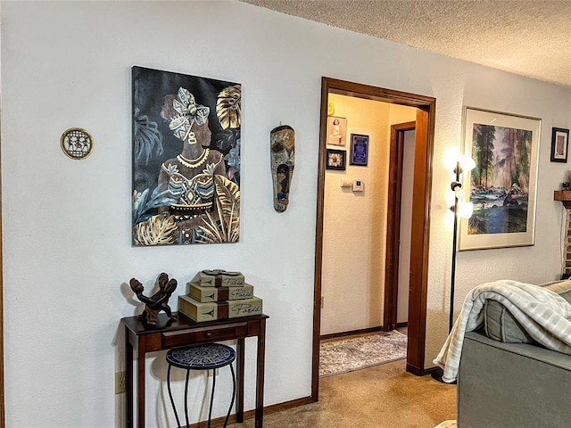 hallway featuring a textured ceiling and carpet flooring