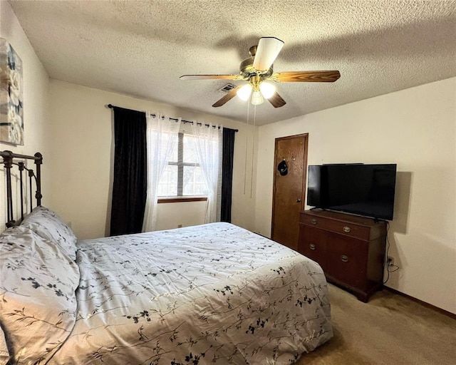 carpeted bedroom featuring ceiling fan and a textured ceiling