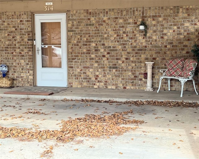 view of exterior entry with a patio area