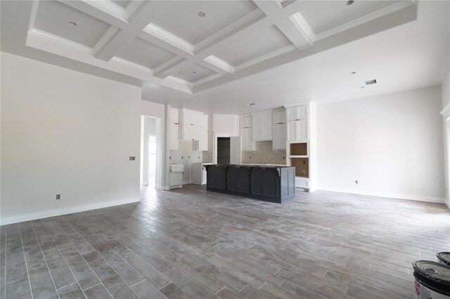 9237 NW 86th St, Yukon, OK 73099 - unfurnished living room with wood finished floors, crown molding, beamed ceiling, coffered ceiling, and baseboards