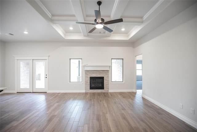9237 NW 86th St, Yukon, OK 73099 - unfurnished living room featuring a ceiling fan, wood finished floors, beam ceiling, a stone fireplace, and coffered ceiling