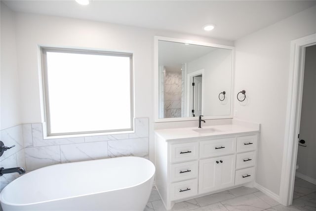 9237 NW 86th St, Yukon, OK 73099 - bathroom featuring marble look tile flooring, a freestanding tub, vanity, tile walls, and recessed lighting