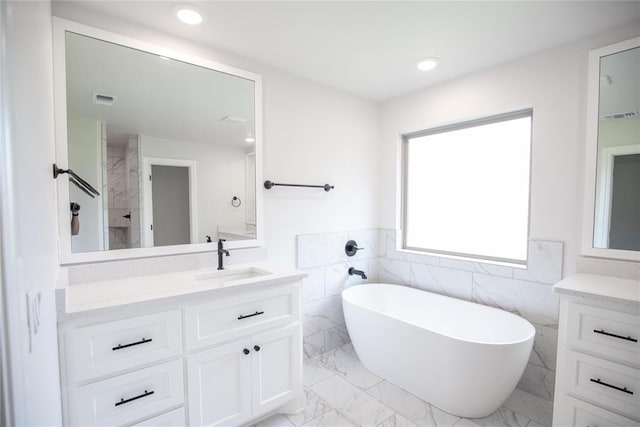 9237 NW 86th St, Yukon, OK 73099 - bathroom with vanity, a freestanding bath, tile walls, marble finish floors, and wainscoting