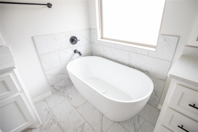 9237 NW 86th St, Yukon, OK 73099 - bathroom featuring marble finish floors, a freestanding bath, vanity, and tile walls