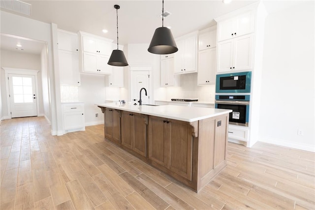 11813 Ethan Mark Dr, Yukon, OK 73099 - kitchen featuring oven, a sink, black microwave, light wood-type flooring, and recessed lighting