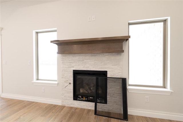 11813 Ethan Mark Dr, Yukon, OK 73099 - detailed view of wood finished floors, baseboards, and a stone fireplace