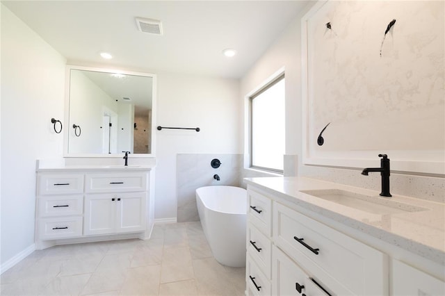 11813 Ethan Mark Dr, Yukon, OK 73099 - full bathroom with two vanities, a freestanding bath, baseboards, and marble finish flooring