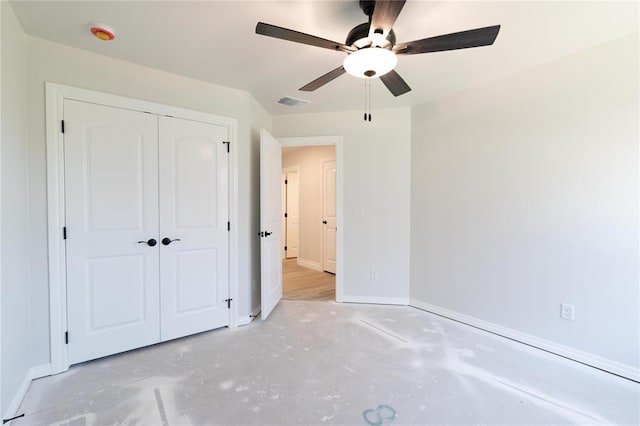 11813 Ethan Mark Dr, Yukon, OK 73099 - unfurnished bedroom with baseboards, concrete floors, a closet, and a ceiling fan