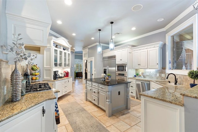 kitchen with built in appliances, a center island, white cabinetry, and tasteful backsplash