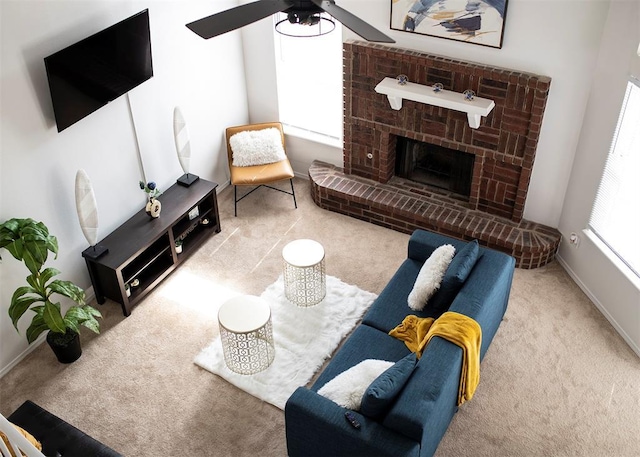 carpeted living room featuring ceiling fan and a brick fireplace