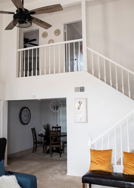 living room featuring ceiling fan and a high ceiling