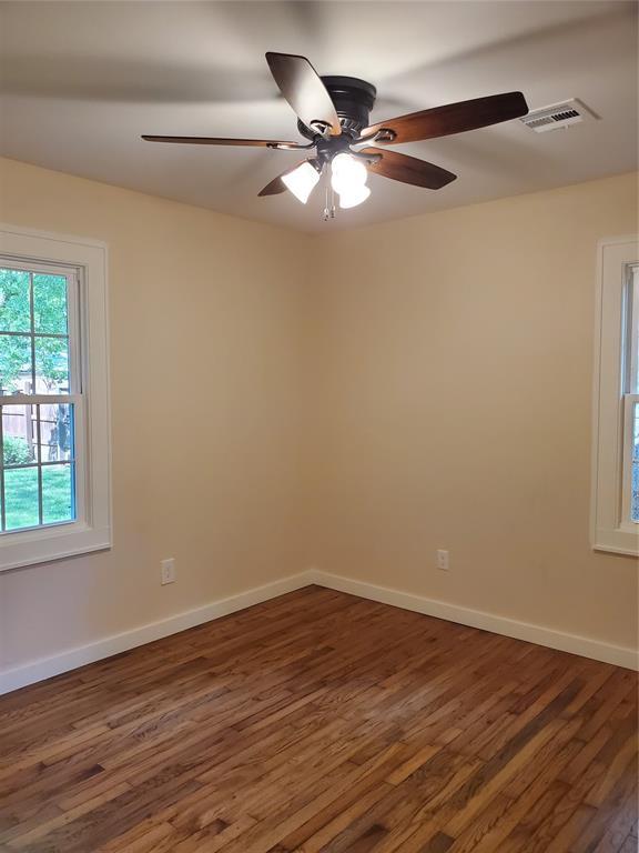 1021 W Apache St, Norman, OK 73069 - spare room with dark wood finished floors, a ceiling fan, and baseboards
