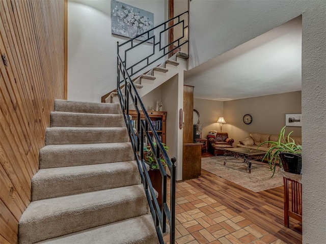 stairway featuring wooden walls