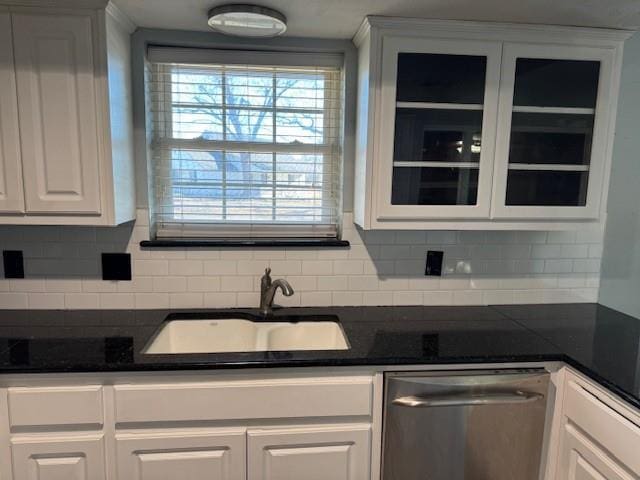 kitchen featuring a sink, dark countertops, white cabinets, and stainless steel dishwasher