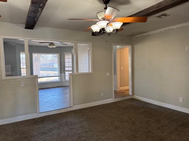 carpeted spare room with a ceiling fan, baseboards, visible vents, and beam ceiling