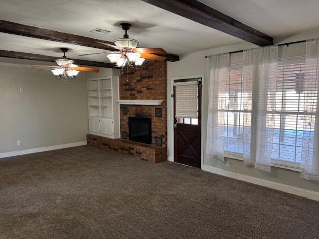 unfurnished living room featuring a fireplace, carpet flooring, visible vents, baseboards, and beamed ceiling