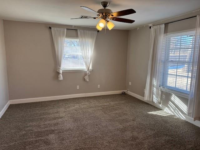 carpeted empty room featuring baseboards and a ceiling fan