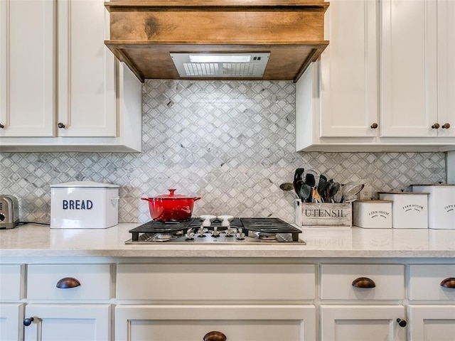 kitchen with premium range hood, decorative backsplash, and white cabinets