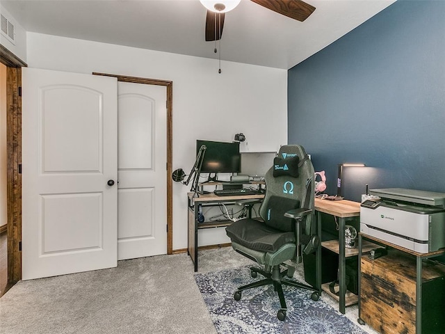 carpeted office space featuring ceiling fan