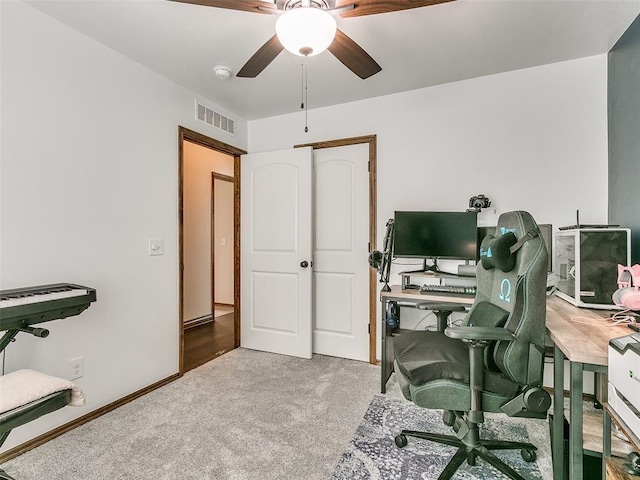 carpeted home office featuring ceiling fan