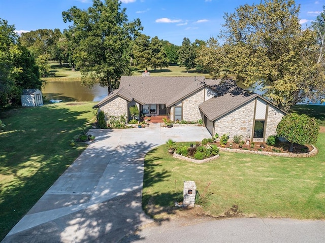 2207 Lake Front Cir, Norman, OK 73069 - view of front facade featuring stone siding, driveway, a water view, and a front yard
