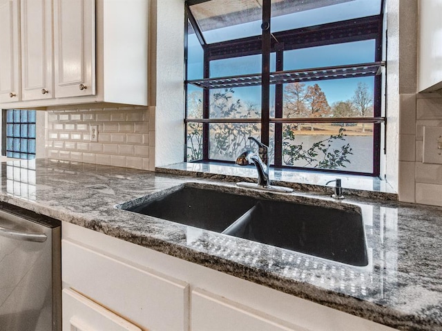 kitchen with white cabinetry, sink, stone countertops, and stainless steel dishwasher