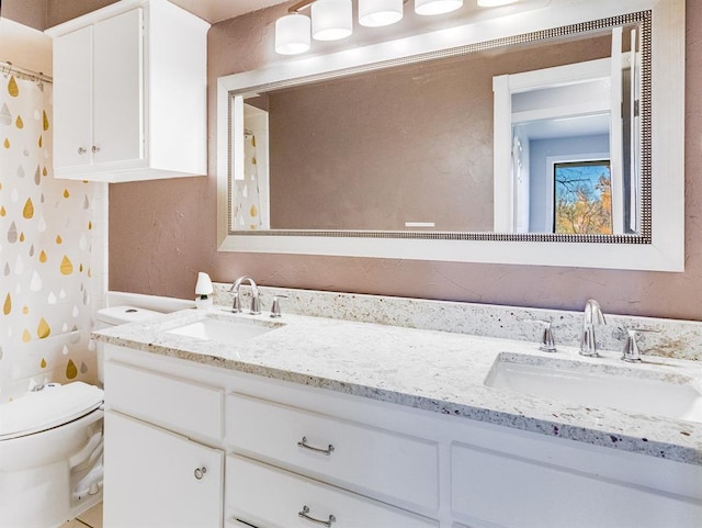 bathroom with toilet, vanity, and a shower with shower curtain