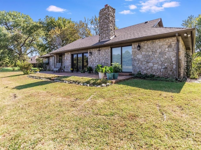 2207 Lake Front Cir, Norman, OK 73069 - rear view of property featuring stone siding, a chimney, a yard, and a patio