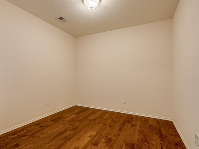 unfurnished room featuring dark wood-type flooring