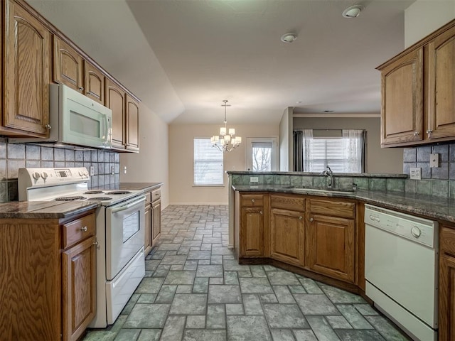 kitchen featuring white appliances, backsplash, an inviting chandelier, sink, and decorative light fixtures