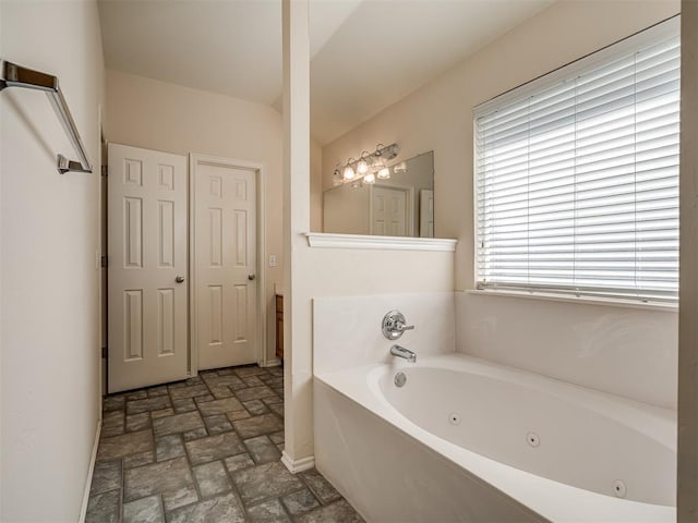 bathroom featuring a washtub and vanity