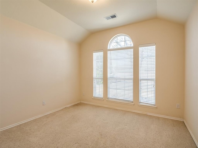 unfurnished room with light carpet and lofted ceiling