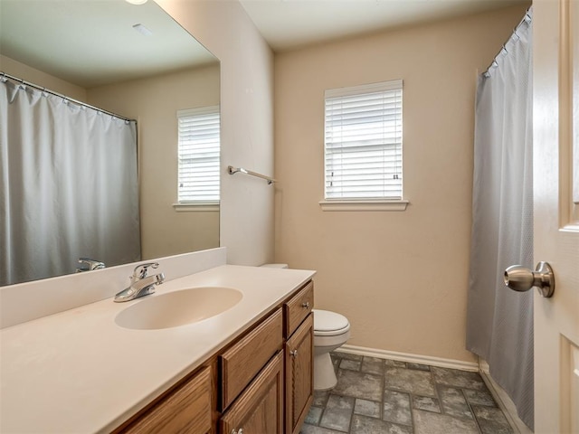 bathroom with a wealth of natural light, vanity, and toilet