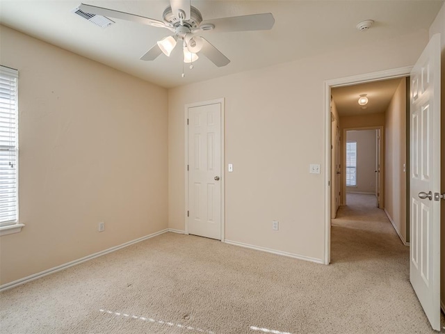 carpeted empty room featuring ceiling fan and a healthy amount of sunlight