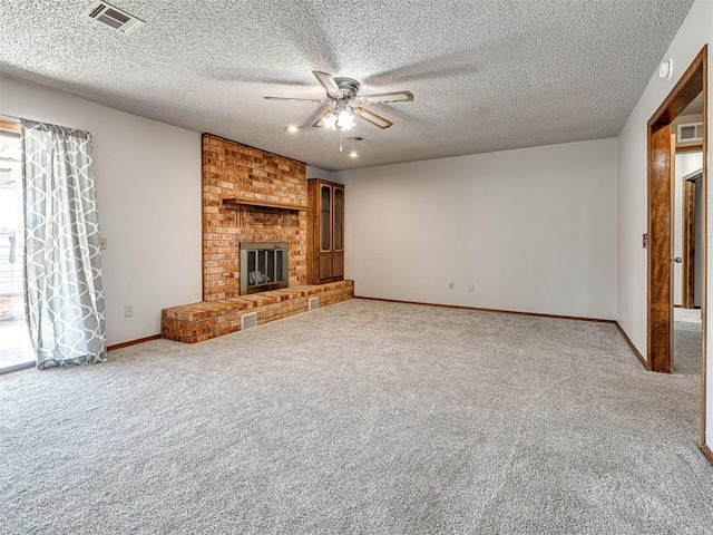 unfurnished living room with ceiling fan, a fireplace, carpet, and a textured ceiling