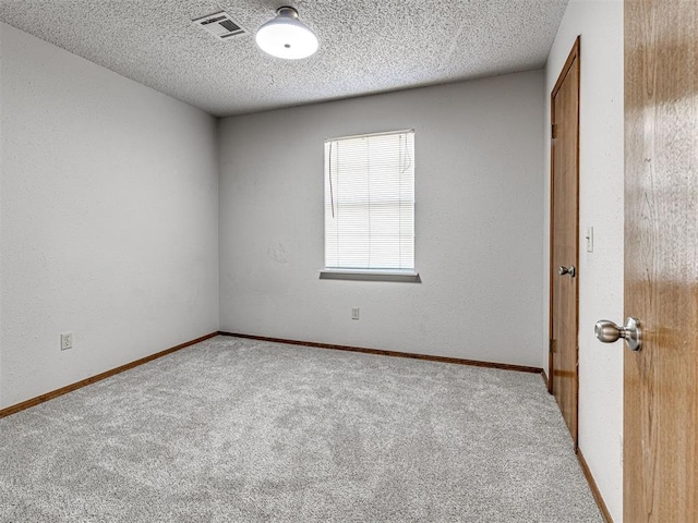 carpeted spare room featuring a textured ceiling