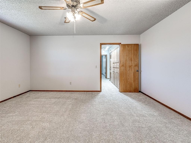 spare room with ceiling fan, light colored carpet, and a textured ceiling