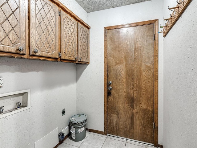 clothes washing area featuring washer hookup, cabinets, hookup for an electric dryer, a textured ceiling, and light tile patterned flooring